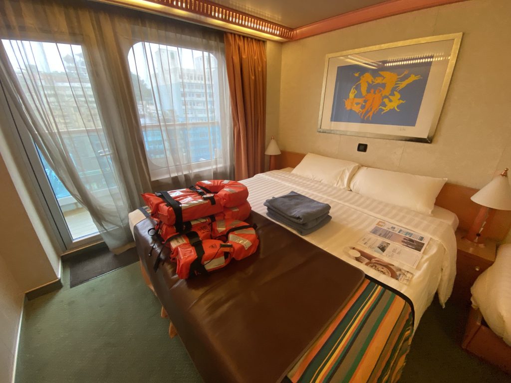 歌詩達郵輪陽台房，可以看到演習用的救生衣跟當日船報在船上